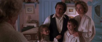 Movie still from “Hook” (1991), directed by Steven Spielberg – A man standing next to two young girls; Medium shot, Low angle