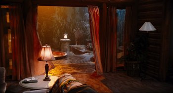 Movie still from “Hot Tub Time Machine” (2010), directed by Steve Pink – A lamp and a couch in a room with curtains; Wide shot, High angle