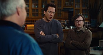 Movie still from “Hot Tub Time Machine” (2010), directed by Steve Pink – A man standing with his arms crossed in front of two other people; Medium shot, Over the shoulder angle