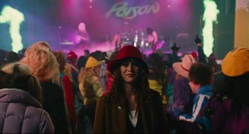Movie still from “Hot Tub Time Machine” (2010), directed by Steve Pink – A woman wearing a red hat in front of a crowd of people; Medium shot, Over the shoulder angle