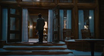 Movie still from “Hot Tub Time Machine” (2010), directed by Steve Pink – A man standing on the steps of a house looking out the window; Wide shot, Low angle