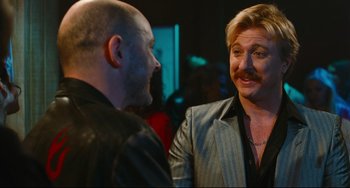 Movie still from “Hot Tub Time Machine” (2010), directed by Steve Pink – Two men talking to each other in front of a crowd; Close Up shot, Over the shoulder angle