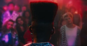 Movie still from “Hot Tub Time Machine” (2010), directed by Steve Pink – A person with a very large red mohawk on their head; Close Up shot, Over the shoulder angle