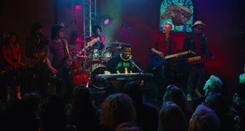 Movie still from “Hot Tub Time Machine” (2010), directed by Steve Pink – A group of people on a stage playing instruments; Wide shot, High angle