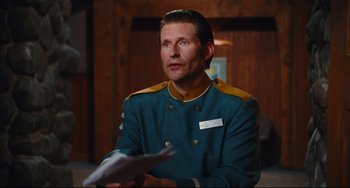 Movie still from “Hot Tub Time Machine” (2010), directed by Steve Pink – A man in a blue and yellow uniform talking to someone; Medium shot, Over the shoulder angle