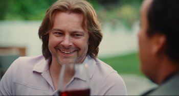 Movie still from “Hot Tub Time Machine” (2010), directed by Steve Pink – A person sitting with a glass of red wine; Close Up shot, Over the shoulder angle