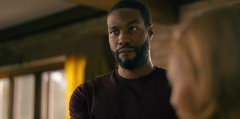 Movie still from “Black Mirror” (2011), created by Charlie Brooker – A person with a beard; Close Up shot, Over the shoulder angle