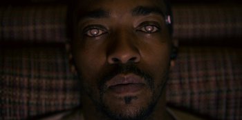 Movie still from “Black Mirror” (2011), created by Charlie Brooker – A man's eyes with a dark background; Extreme Close Up shot, Overhead angle
