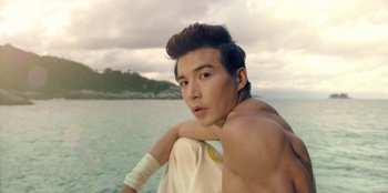 Movie still from “Black Mirror” (2011), created by Charlie Brooker – A young man sitting on top of a boat in the water; Close Up shot, Low angle