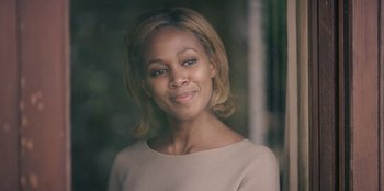 Movie still from “Black Mirror” (2011), created by Charlie Brooker – A woman in a white shirt is smiling for the camera; Close Up shot, Low angle