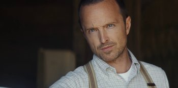 Movie still from “Black Mirror” (2011), created by Charlie Brooker – A person wearing a plaid shirt and suspenders; Close Up shot, Low angle