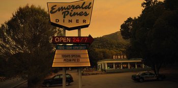Movie still from “Black Mirror” (2011), created by Charlie Brooker – A sign for emerald pines diner on the side of the road; Extreme Wide shot, High angle