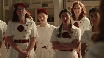 Movie still from “A League of Their Own” (2022), created by Abbi Jacobson – A group of young women in white uniforms standing next to each other; Medium shot, Low angle