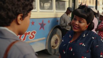 Movie still from “A League of Their Own” (2022), created by Abbi Jacobson – A woman standing in front of a bus talking to a man; Close Up shot, Over the shoulder angle