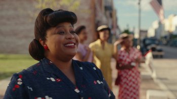 Movie still from “A League of Their Own” (2022), created by Abbi Jacobson – A woman with a large smile on her face; Close Up shot, Over the shoulder angle