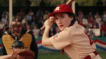 Movie still from “A League of Their Own” (2022), created by Abbi Jacobson – A woman holding a baseball bat while wearing a baseball uniform; Close Up shot, Over the shoulder angle