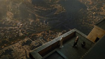 Movie still from “Game of Thrones” (2011), created by D.B. Weiss – Two people are standing on a ledge overlooking a city; Extreme Wide shot, High angle