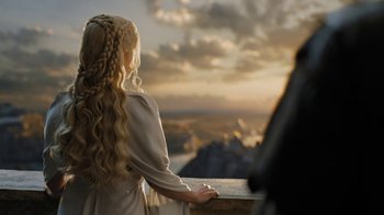 Movie still from “Game of Thrones” (2011), created by D.B. Weiss – A woman with long blonde hair standing next to a railing looking out at the sky; Close Up shot, Over the shoulder angle