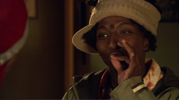 Movie still from “How High” (2001), directed by Jesse Dylan – A man in a hat is holding his hand to his face; Close Up shot, Low angle