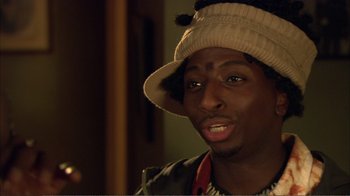 Movie still from “How High” (2001), directed by Jesse Dylan – A man wearing a white hat and a brown jacket; Close Up shot, Over the shoulder angle