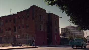 Movie still from “How High” (2001), directed by Jesse Dylan – A man walking down the sidewalk in front of a building; Extreme Wide shot, Low angle