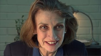 Movie still from “How High” (2001), directed by Jesse Dylan – An older woman wearing pearls and a blue jacket; Close Up shot, Over the shoulder angle