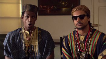 Movie still from “How High” (2001), directed by Jesse Dylan – A couple of men sitting next to each other in a room; Medium shot, Low angle