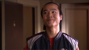 Movie still from “How High” (2001), directed by Jesse Dylan – A young man with long black hair wearing a red and blue jacket; Close Up shot, Over the shoulder angle