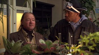 Movie still from “How High” (2001), directed by Jesse Dylan – Two men sitting at a table with plants in front of them; Medium shot, Over the shoulder angle
