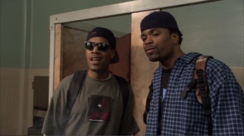 Movie still from “How High” (2001), directed by Jesse Dylan – Two men standing next to each other in front of a wall; Medium shot, Low angle