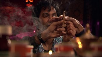 Movie still from “How High” (2001), directed by Jesse Dylan – A man smoking a cigarette in front of candles; Close Up shot, Over the shoulder angle