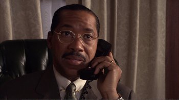 Movie still from “How High” (2001), directed by Jesse Dylan – A man in a suit and tie talking on a phone; Close Up shot, Low angle