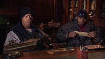 Movie still from “How High” (2001), directed by Jesse Dylan – A couple of men sitting at a wooden table; Medium shot, High angle