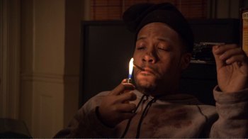 Movie still from “How High” (2001), directed by Jesse Dylan – A man lighting a candle in a dark room; Close Up shot, High angle