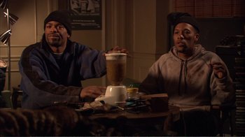 Movie still from “How High” (2001), directed by Jesse Dylan – Two men sitting at a table with a blender; Medium shot, High angle