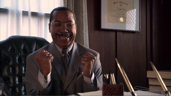 Movie still from “How High” (2001), directed by Jesse Dylan – A man in a suit and tie sitting at a table; Medium shot, Low angle