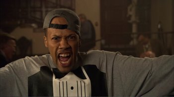 Movie still from “How High” (2001), directed by Jesse Dylan – A man in a hat and a gray shirt is yelling; Close Up shot, Low angle