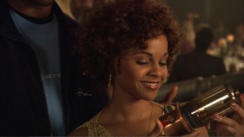 Movie still from “How High” (2001), directed by Jesse Dylan – A beautiful woman with curly brown hair holding a bottle; Close Up shot, Over the shoulder angle