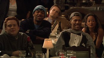 Movie still from “How High” (2001), directed by Jesse Dylan – A group of men sitting at a table with drinks; Medium shot, Over the shoulder angle
