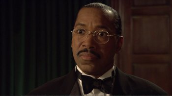 Movie still from “How High” (2001), directed by Jesse Dylan – An older man wearing a suit and bow tie; Close Up shot, Low angle