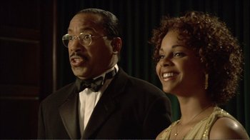 Movie still from “How High” (2001), directed by Jesse Dylan – A man and a woman standing next to each other in front of a green curtain; Close Up shot, Low angle