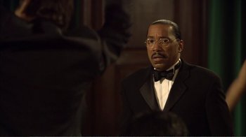 Movie still from “How High” (2001), directed by Jesse Dylan – A man in a suit and bow - tie looking at the camera; Close Up shot, Over the shoulder angle