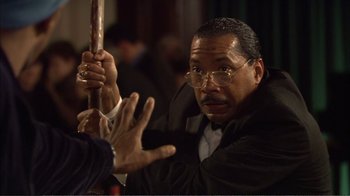 Movie still from “How High” (2001), directed by Jesse Dylan – An older man holding a stick in front of another man; Close Up shot, Over the shoulder angle