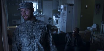 Movie still from “Black Summer” (2019), created by John Hyams – A man in a military fatigues standing next to another man; Medium shot, Over the shoulder angle