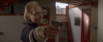 Movie still from “In the Line of Fire” (1993), directed by Wolfgang Petersen – A man holding a gun in a room with a ladder; Close Up shot, Low angle