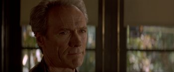 Movie still from “In the Line of Fire” (1993), directed by Wolfgang Petersen – An older man is looking into the camera; Close Up shot, Over the shoulder angle