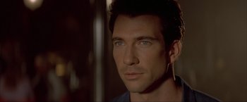 Movie still from “In the Line of Fire” (1993), directed by Wolfgang Petersen – Close up of a man's face in a dark room; Close Up shot, Over the shoulder angle