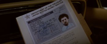 Movie still from “In the Line of Fire” (1993), directed by Wolfgang Petersen – A person's driver's license on top of a table; Extreme Close Up shot, High angle