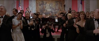 Movie still from “In the Line of Fire” (1993), directed by Wolfgang Petersen – A group of people that are standing in a room; Wide shot, Low angle