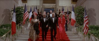 Movie still from “In the Line of Fire” (1993), directed by Wolfgang Petersen – A group of men and women walking down a red carpet; Wide shot, High angle